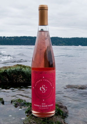 Bottle of Sunken Cellar's rosé in front of the ocean